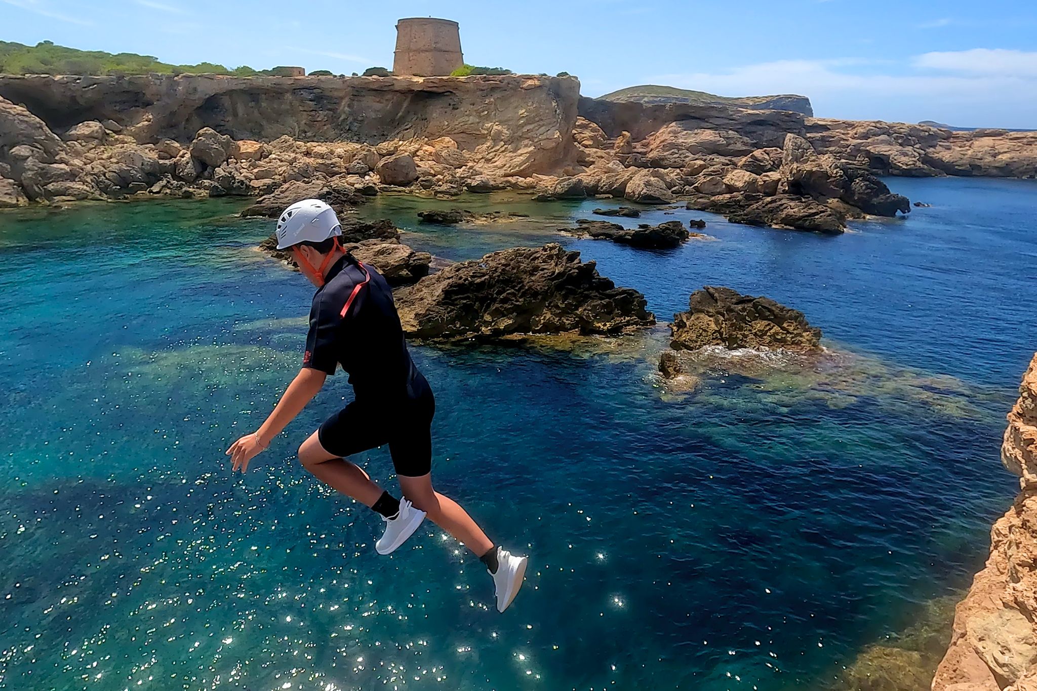 Family kid coasteering in Ibiza at Cala Comte with an optional guided sea jump